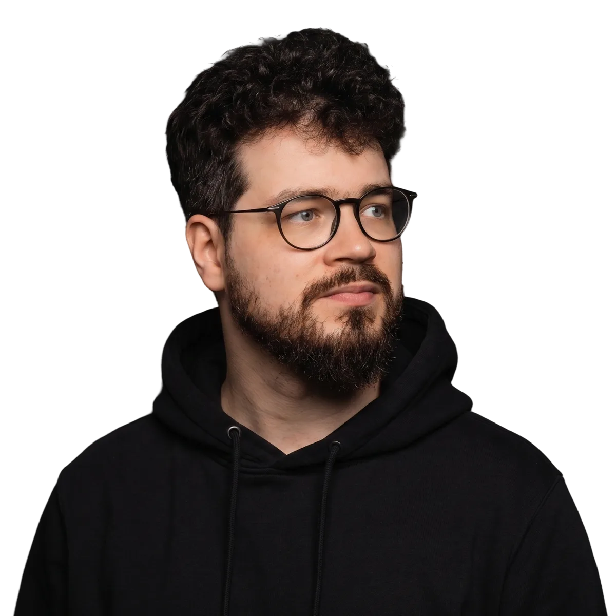 Portrait of Roni Helppi — a studio headshot with glasses, a short beard, and a black hoodie against a dark background.